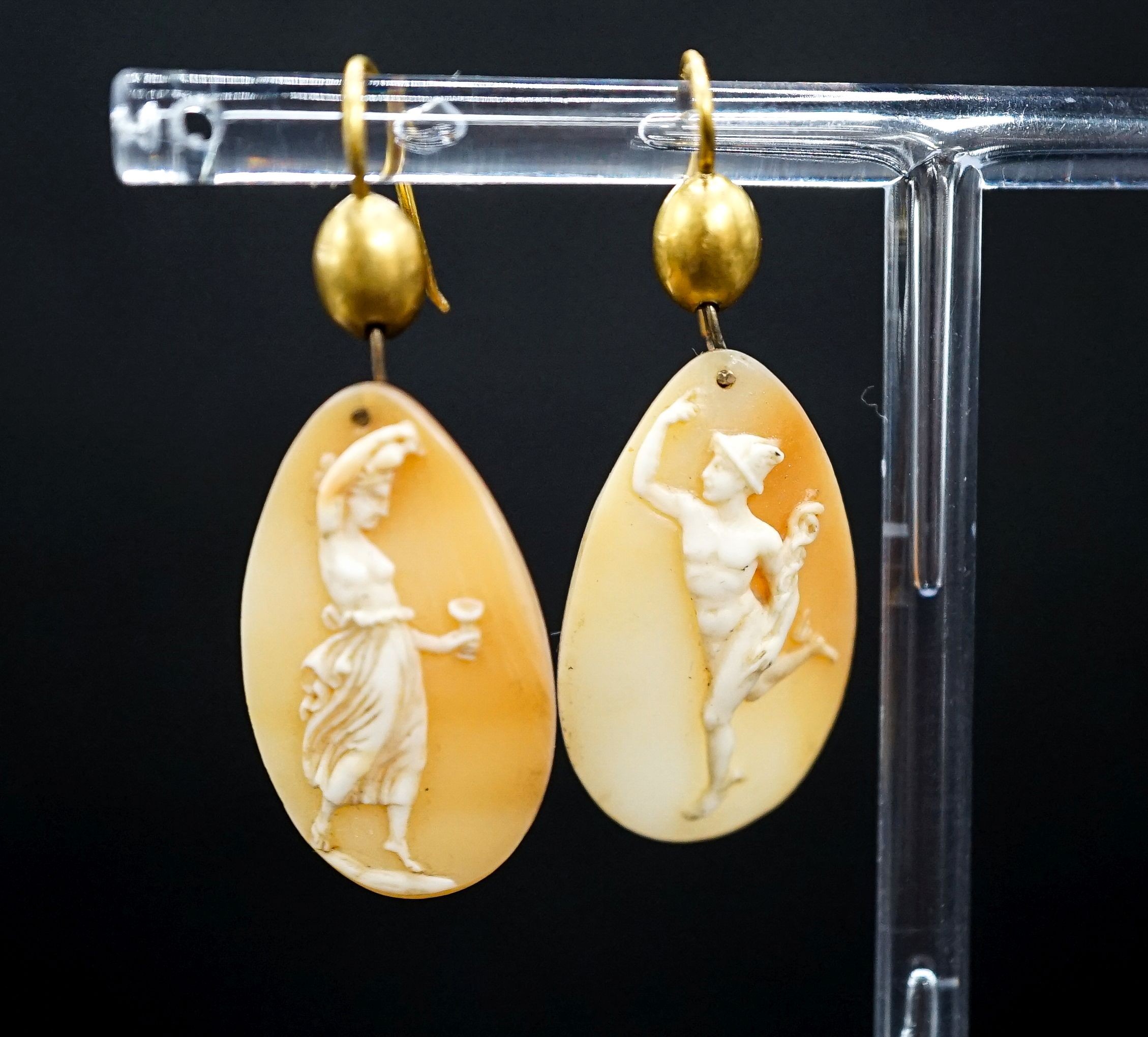 A pair of Victorian yellow metal and cameo shell ovoid earrings, carved with Mercury & Flora, shell 26mm.